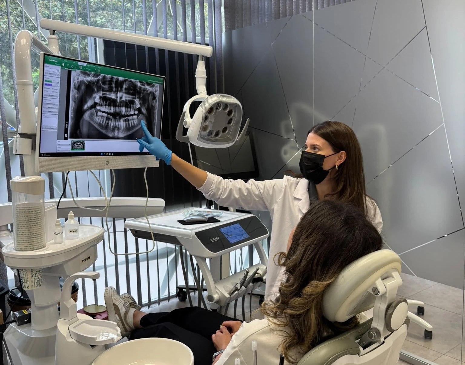 Dt. Asrın Şen DentaFİX Bayraklı kliniğinde hastaya radyografik değerlendirme yaparken